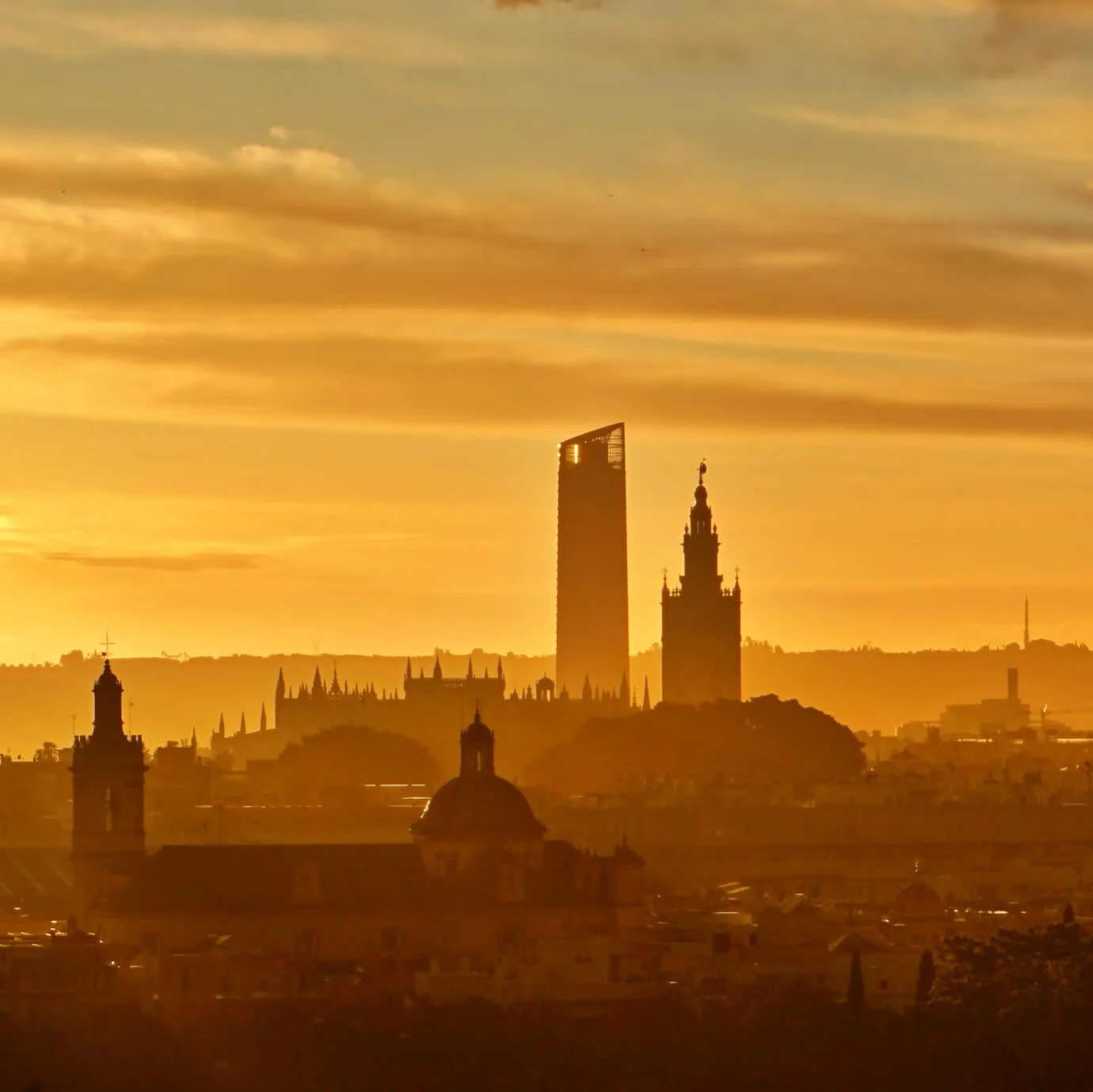 A silhouette of the city from a distance as the sun sets