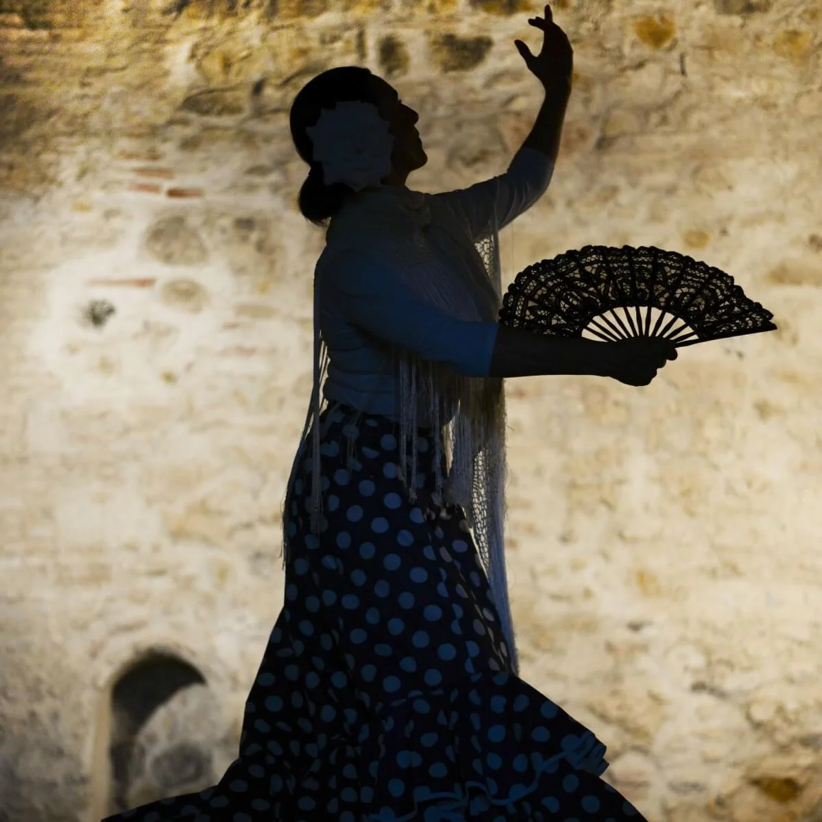 A woman dancing flamenco with a fan